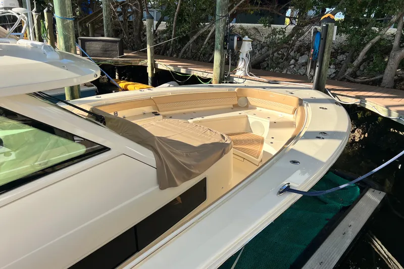 Slide: The Image of 2024 Scout 425 LXF boat docked, featuring spacious seating and sleek design. - 19