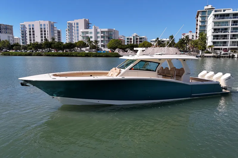 Slide: The Image of 2024 Scout 425 LXF boat on water, modern buildings in background. - 3