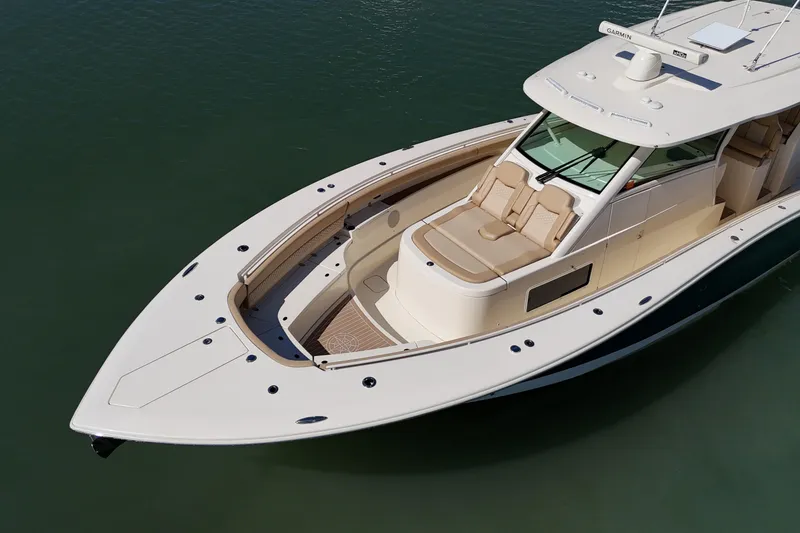 Slide: The Image of 2024 Scout 425 LXF luxury boat on calm water, showcasing sleek design and spacious deck. - 5