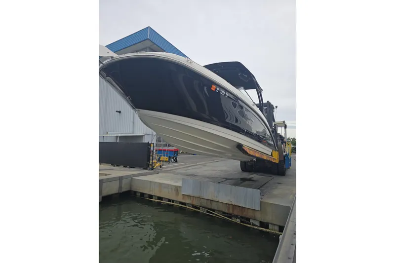 The Image of 2023 Sea Ray SDX 270 Outboard boat on trailer, black hull, sunny day. - 0