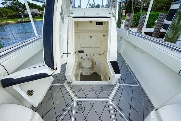 Slide: The Image of 2007 Spectre 37 Center Console boat with white seating and sleek design at a dock. - 14