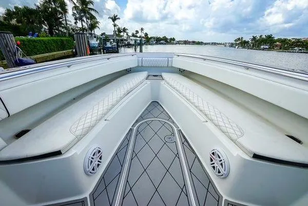 Slide: The Image of 2007 Spectre 37 Center Console boat interior with steering wheel and seating, docked by a scenic waterfront. - 17