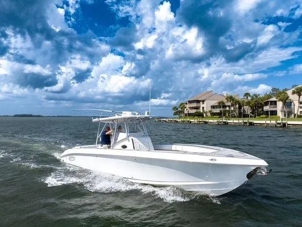 Slide: The Image of 2007 Spectre 37 Center Console boat cruising on a scenic waterway with cloudy skies. - 8