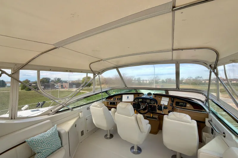 Slide: The Image of Interior view of 2003 Carver 564 Cockpit Motor Yacht helm with white seating. - 15