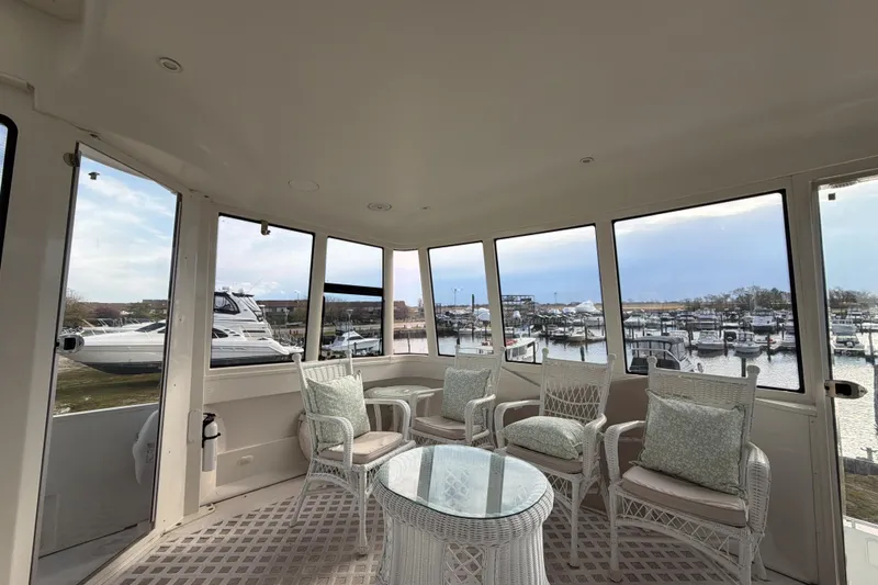 Slide: The Image of Interior of 2003 Carver 564 Cockpit Motor Yacht with wicker seating and marina view. - 16