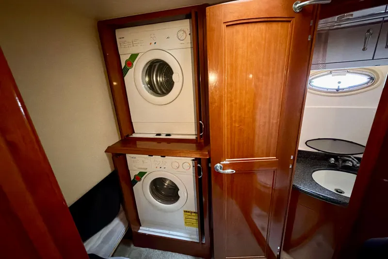 Slide: The Image of Laundry area in 2003 Carver 564 Cockpit Motor Yacht with stacked washer and dryer. - 36