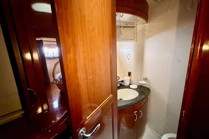 Slide: The Image of 2003 Carver 564 Cockpit Motor Yacht bathroom with wooden cabinetry and sink. - 38