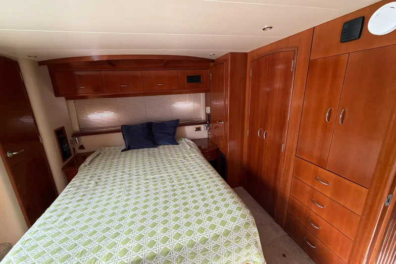 Slide: The Image of Luxurious bedroom interior of 2003 Carver 564 Cockpit Motor Yacht with wooden cabinetry. - 41