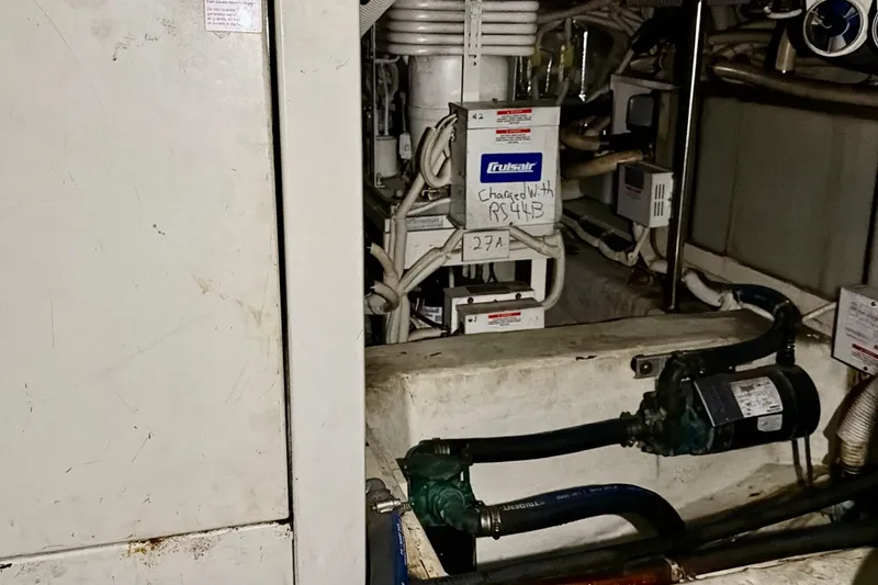 Slide: The Image of Engine room of 2003 Carver 564 Cockpit Motor Yacht with visible machinery and wiring. - 56