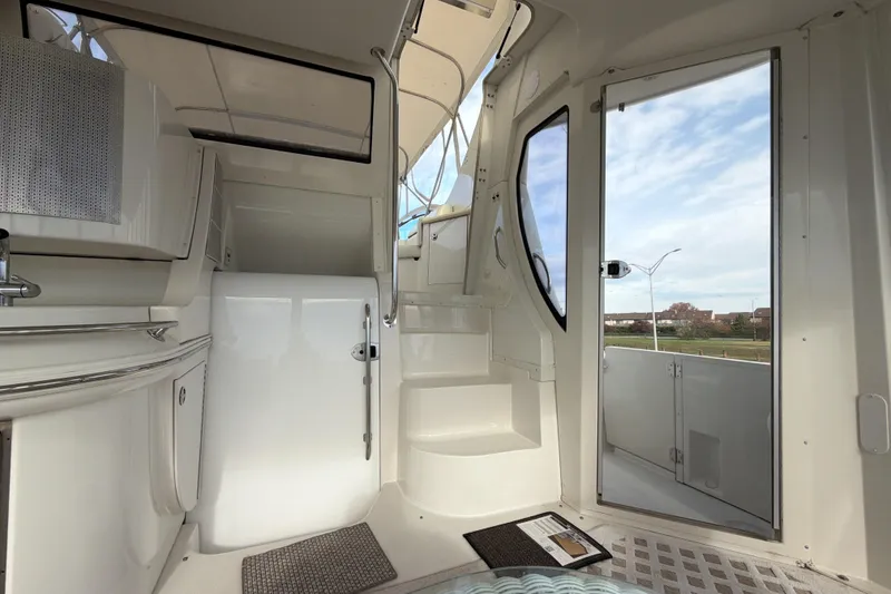 Slide: The Image of Interior view of 2003 Carver 564 Cockpit Motor Yacht, featuring sleek white design and outdoor access. - 18