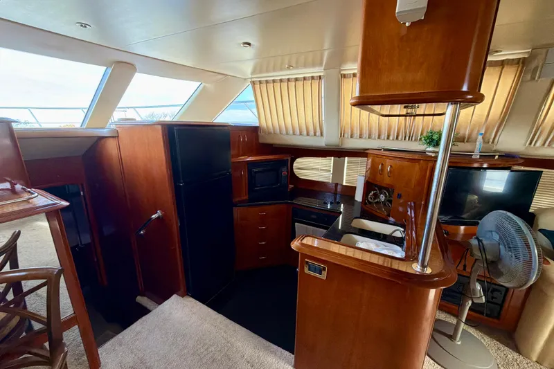 Slide: The Image of Luxurious interior of 2003 Carver 564 Cockpit Motor Yacht with kitchen and seating area. - 22