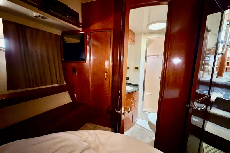Slide: The Image of Interior of 2003 Carver 564 Cockpit Motor Yacht with wood finishes and compact bathroom. - 33