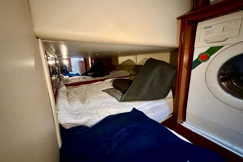 Slide: The Image of Cozy cabin interior of 2003 Carver 564 Cockpit Motor Yacht with bedding and washing machine. - 39