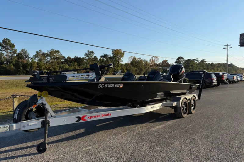 Slide: The Image of 2025 Xpress X21 Pro boat on trailer in parking lot, sunny day. - 2