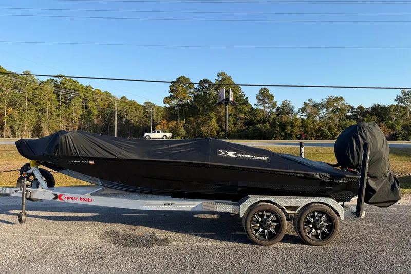 Slide: The Image of 2025 Xpress X21 Pro boat covered on trailer, parked outdoors. - 20