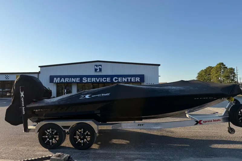 Slide: The Image of 2025 Xpress X21 Pro boat covered on trailer at Marine Service Center. - 21