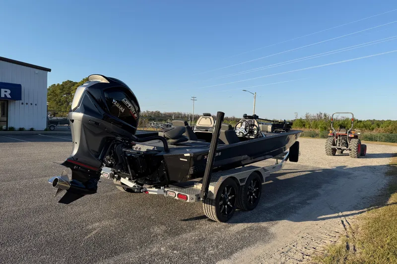 Slide: The Image of 2025 Xpress X21 Pro boat on trailer with powerful outboard motor, parked outdoors. - 6