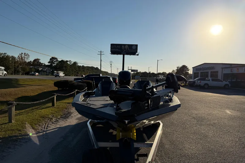 Slide: The Image of 2025 Xpress X21 Pro boat on trailer, parked roadside under bright sun. - 7