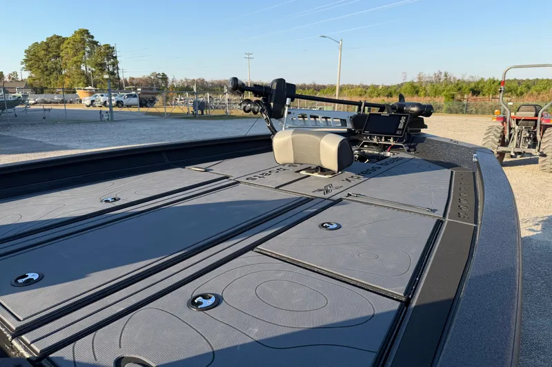 Slide: The Image of 2025 Xpress X21 Pro boat deck with advanced fishing equipment, parked outdoors. - 9
