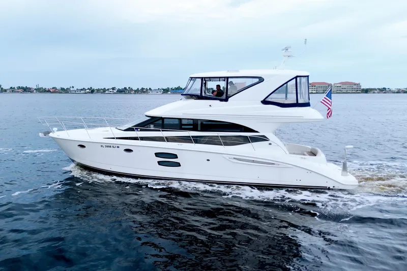 Slide: The Image of 2013 Meridian 441 Sedan yacht cruising on calm waters with American flag. - 11