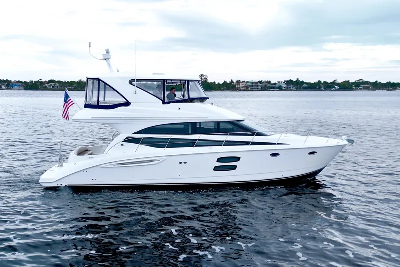 Slide: The Image of 2013 Meridian 441 Sedan yacht cruising on calm waters with American flag. - 13