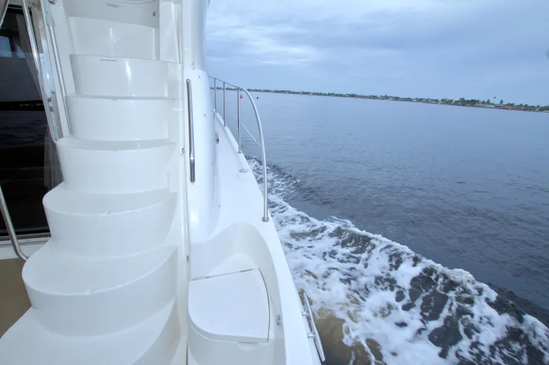 Slide: The Image of 2013 Meridian 441 Sedan yacht with white stairs, cruising on calm waters. - 27