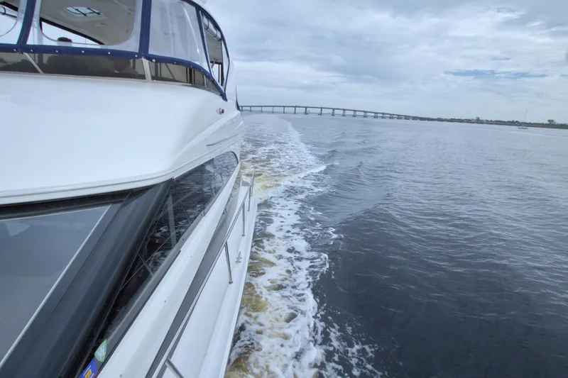 Slide: The Image of 2013 Meridian 441 Sedan cruising on open water with bridge in background. - 34