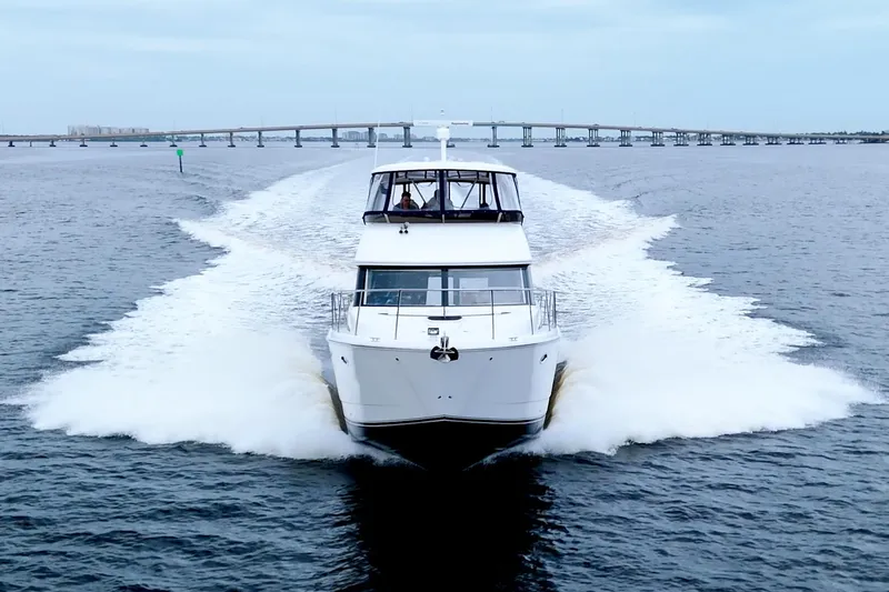Slide: The Image of 2013 Meridian 441 Sedan yacht cruising on open water with bridge in background. - 7