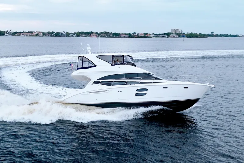 Slide: The Image of 2013 Meridian 441 Sedan yacht cruising on open water, creating a wake. - 9