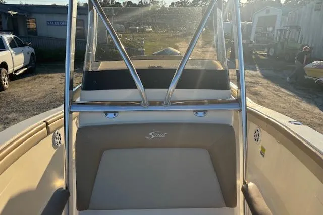 Slide: The Image of 2022 Scout 215 XSF boat interior with seating and console in a sunny outdoor setting. - 15