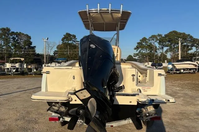Slide: The Image of 2022 Scout 215 XSF boat with outboard motor, parked outdoors. - 2