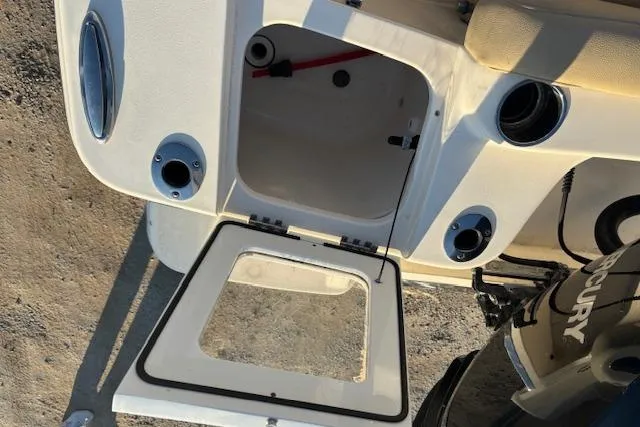 Slide: The Image of 2022 Scout 215 XSF boat storage compartment with open hatch and Mercury engine. - 22