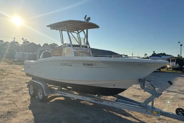 Slide: The Image of 2022 Scout 215 XSF boat on trailer under sunny sky. - 7