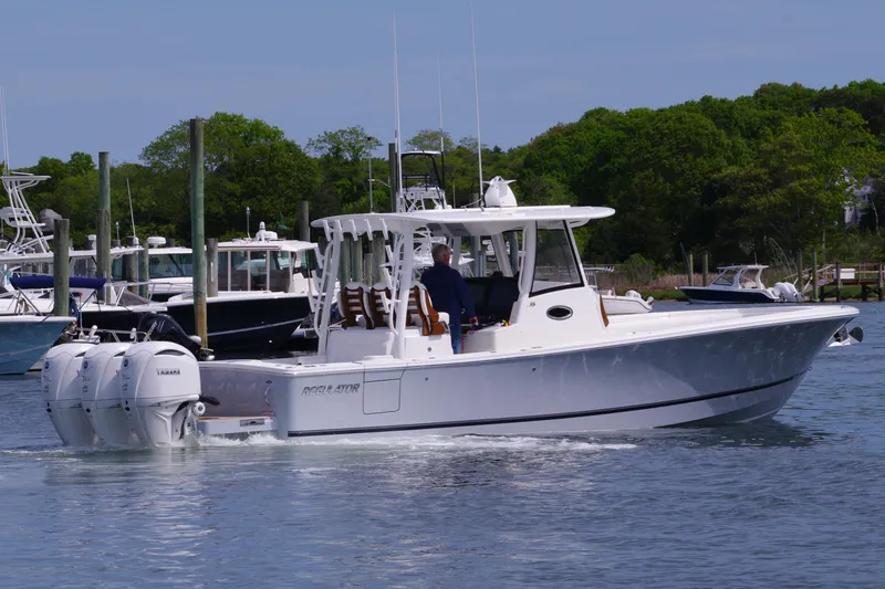 Slide: The Image of 2025 Regulator 35 boat with dual engines cruising in a marina. - 11