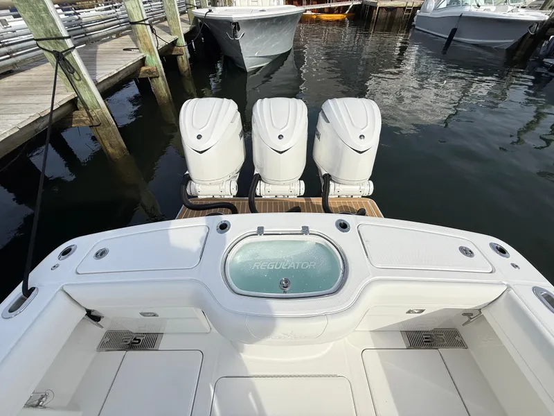 Slide: The Image of 2025 Regulator 35 boat with triple outboard engines docked at marina. - 15