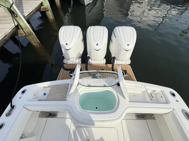 Slide: The Image of 2025 Regulator 35 boat with triple outboard engines docked at marina. - 16