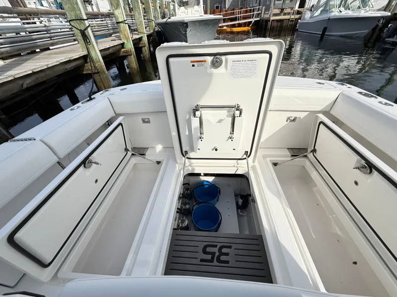 Slide: The Image of 2025 Regulator 35 boat interior with open storage compartments at a marina. - 26