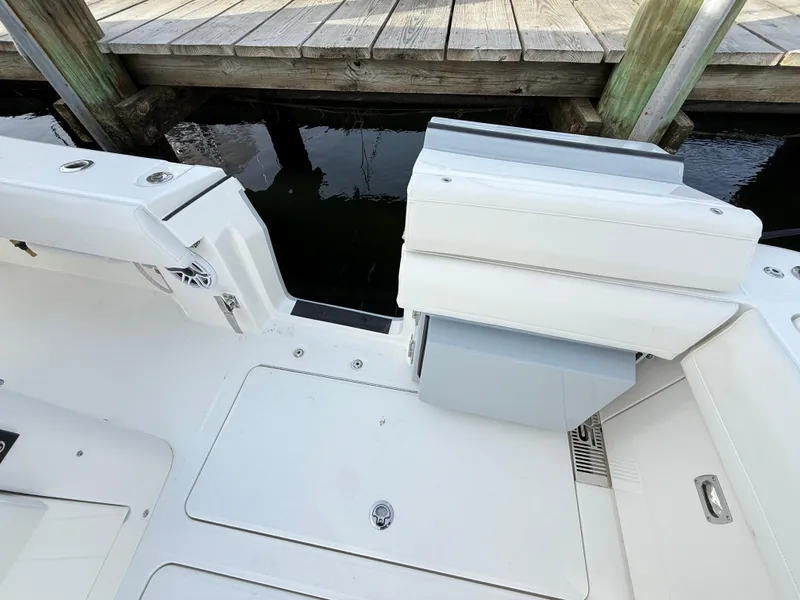 Slide: The Image of 2025 Regulator 35 boat interior, featuring sleek white seating and deck near a wooden dock. - 39