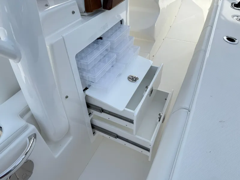 Slide: The Image of 2025 Regulator 35 boat storage compartments with organized tackle boxes and drawers. - 41