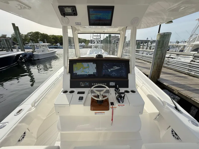 Slide: The Image of 2025 Regulator 35 boat cockpit with advanced navigation system at marina. - 46