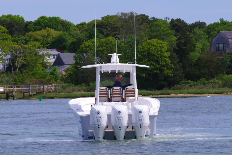 Slide: The Image of 2025 Regulator 35 boat with four engines cruising on a scenic lake. - 9