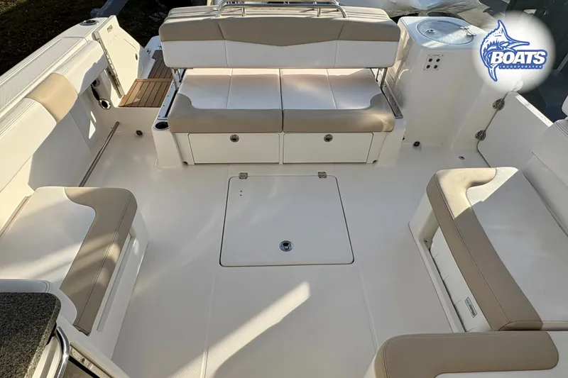 Slide: The Image of 2019 Robalo R317 Dual Console boat interior with beige seating and storage compartments. - 13