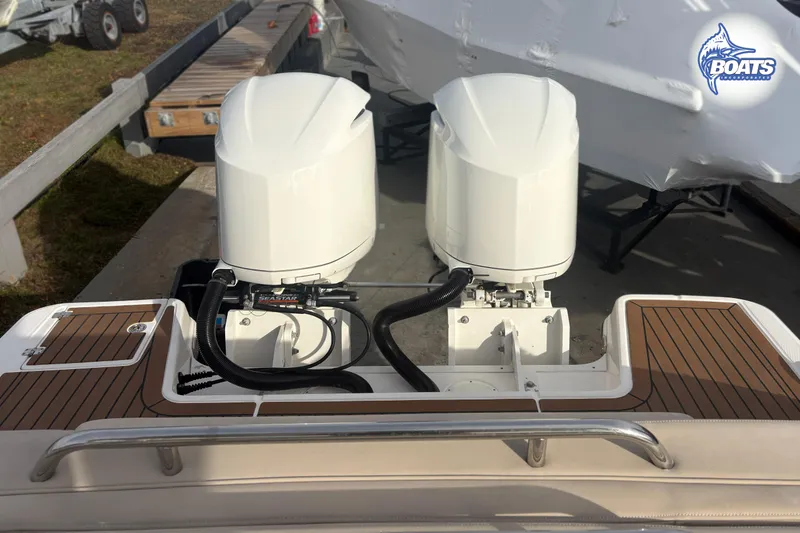 Slide: The Image of 2019 Robalo R317 Dual Console with twin outboard engines on a wooden deck. - 16