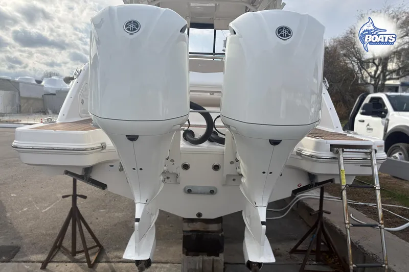 Slide: The Image of 2019 Robalo R317 Dual Console with twin outboard engines, docked on a sunny day. - 17