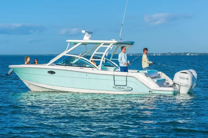 Slide: The Image of Manufacturer Provided Image: 2019 Robalo R317 Dual Console boat on the water with people fishing. - 3