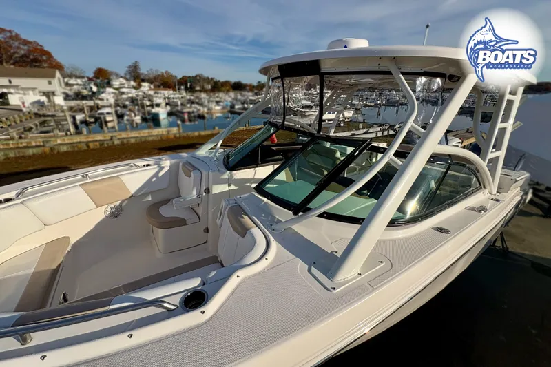Slide: The Image of 2019 Robalo R317 Dual Console boat docked at a marina, showcasing spacious seating. - 5