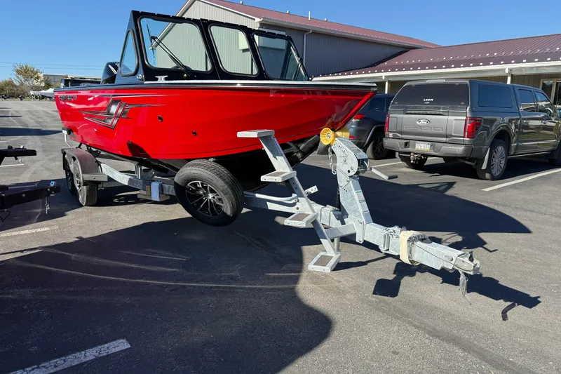 The Image of Red 2026 Crestliner 2050 Commander Elite boat on trailer in parking lot. - 0