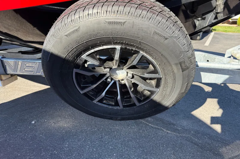 Slide: The Image of Trailer wheel of 2026 Crestliner 2050 Commander Elite, black alloy rim, parked on asphalt. - 5