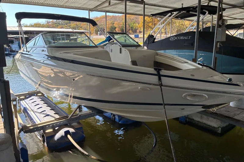 The Image of Cobalt 246 boat from 2000 on a lift in a covered dock area. - 0