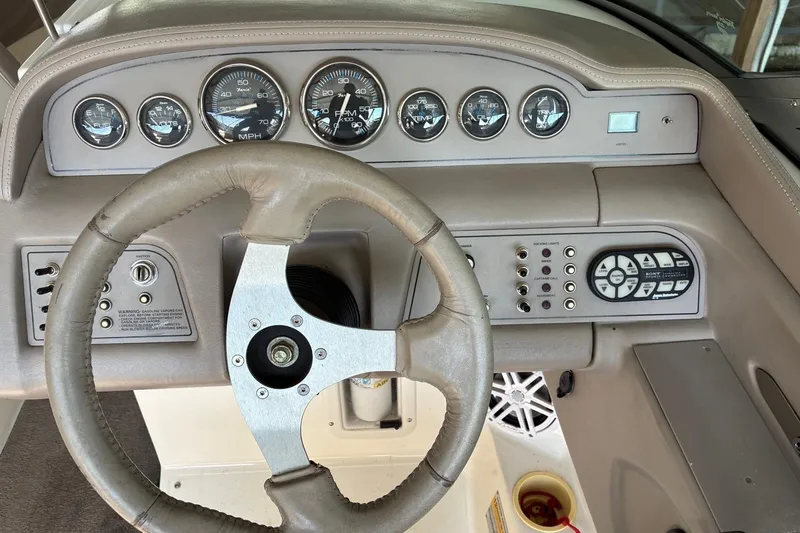 Slide: The Image of Steering wheel and dashboard of a 2000 Cobalt 246 boat with gauges and controls. - 14